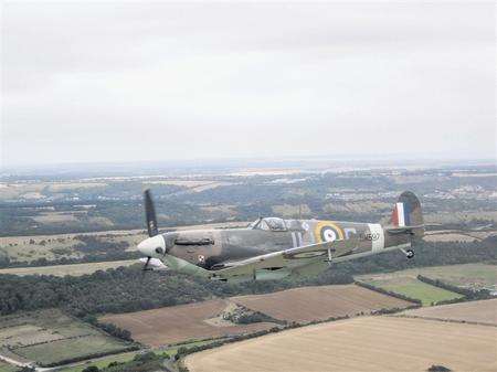 An iconic WWII aircraft flies just metres from one of Action Stations' chartered helicopters