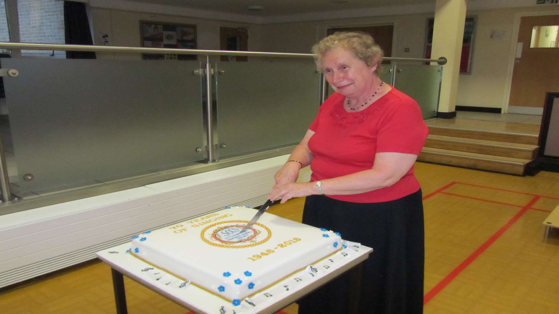 Dot Mills, second longest serving member of the choir, who joined in 1971, cutting the cake