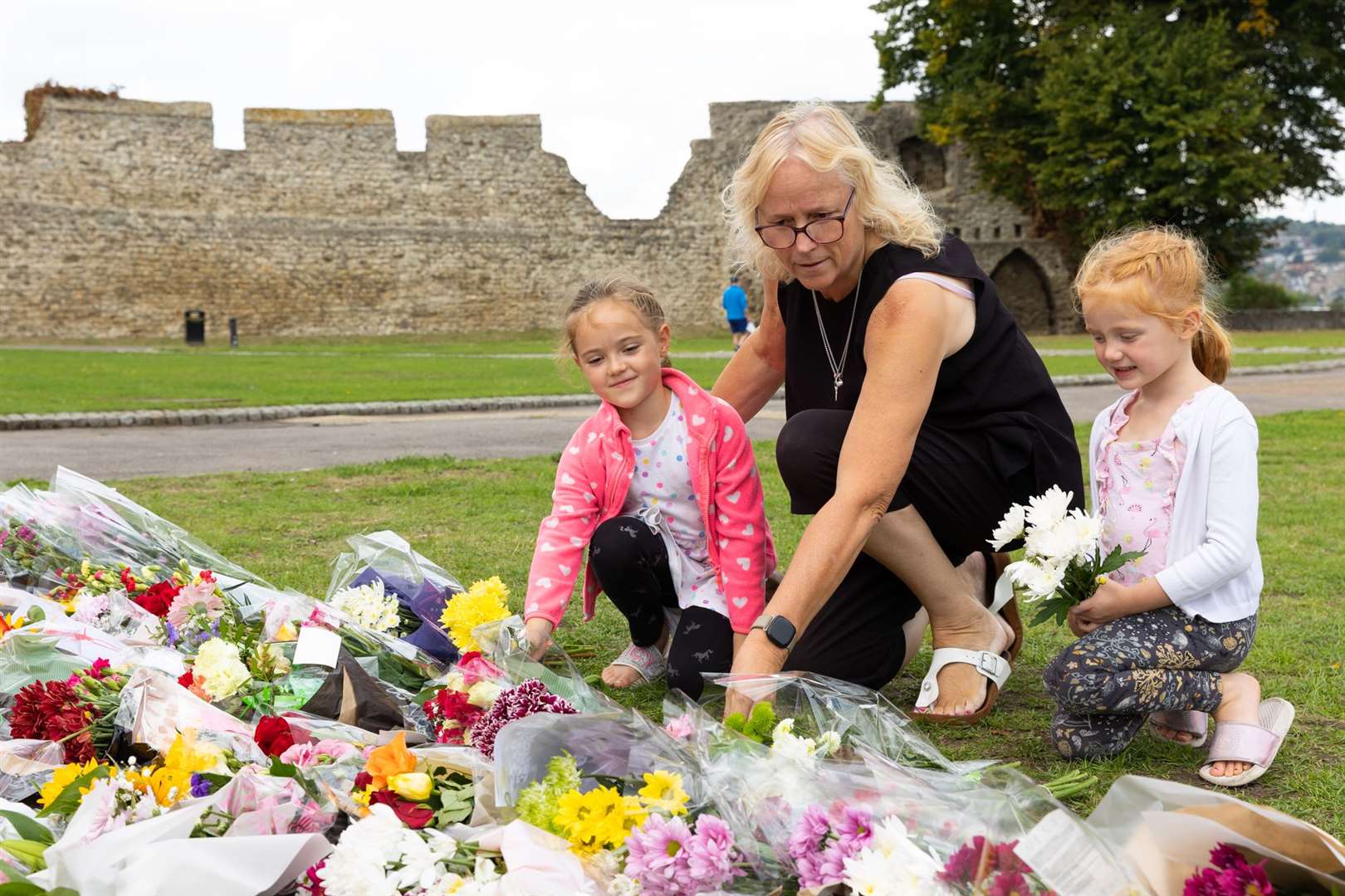 People watch and lay flowers for the Queen at Rochester Castle as the proclamation of the new King takes place. Picture: Medway Council