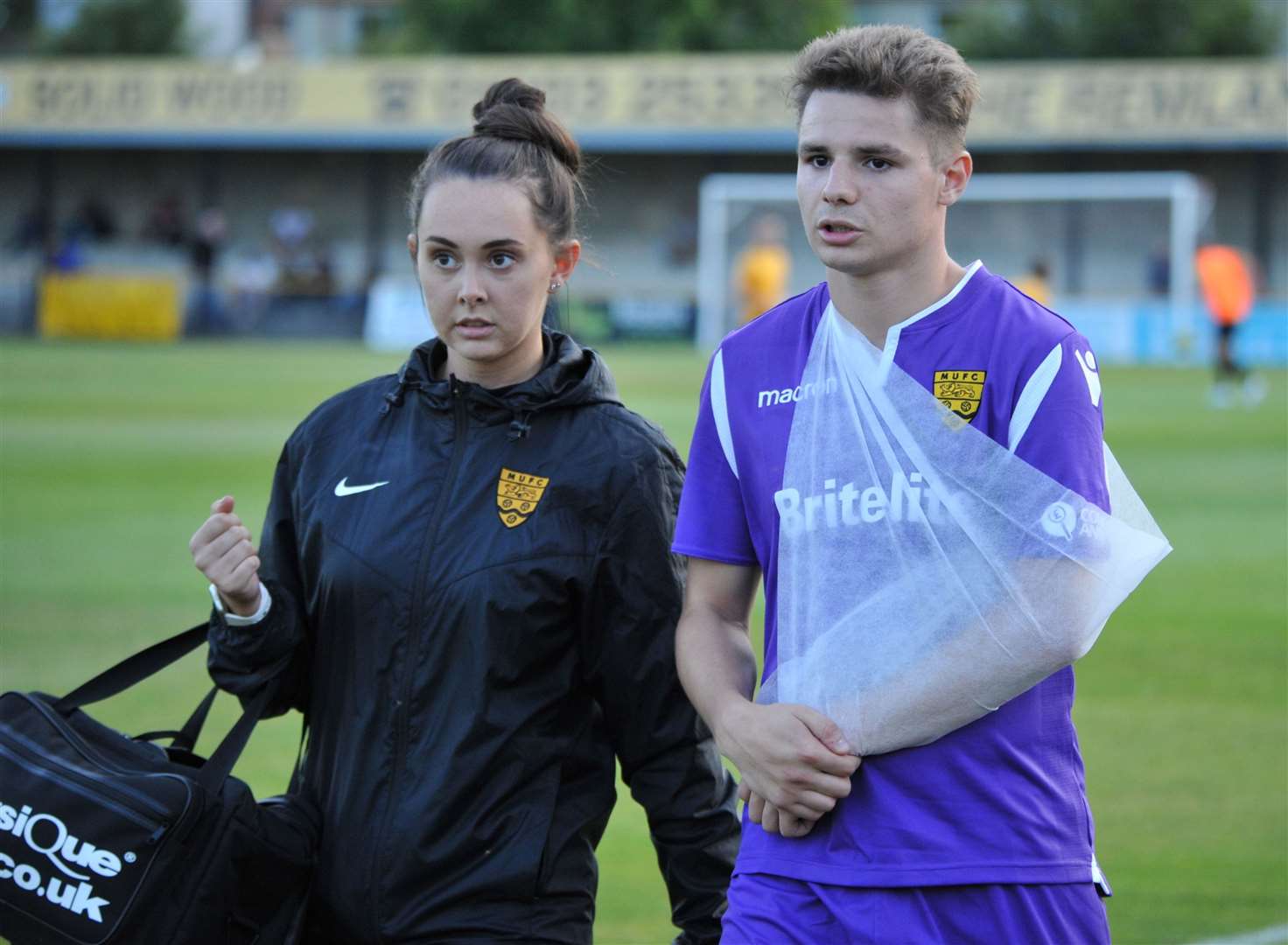 Jake Embery leaves the field at Folkestone with physio Beth Cooper after breaking his collarbone Picture: Steve Terrell