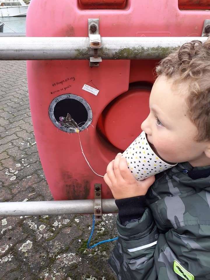 Blake Hervey, 5, has fun trying to speak to Moo Mop Mouse using a paper cup and string attached to a lifebuoy at Queenborough on the Isle of Sheppey. Picture: Teresa Whiskin