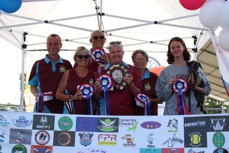 Flyball team "Be Right Back in a Mo" with their rosettes after their win: Russell Phelps (Caspar), Ian Eyres (Rufus), Jackie Payne (Eddie), Sarah Prentice (team captain) Brenda Garrett (Dexter) and Charlotte Prentice (Molly)