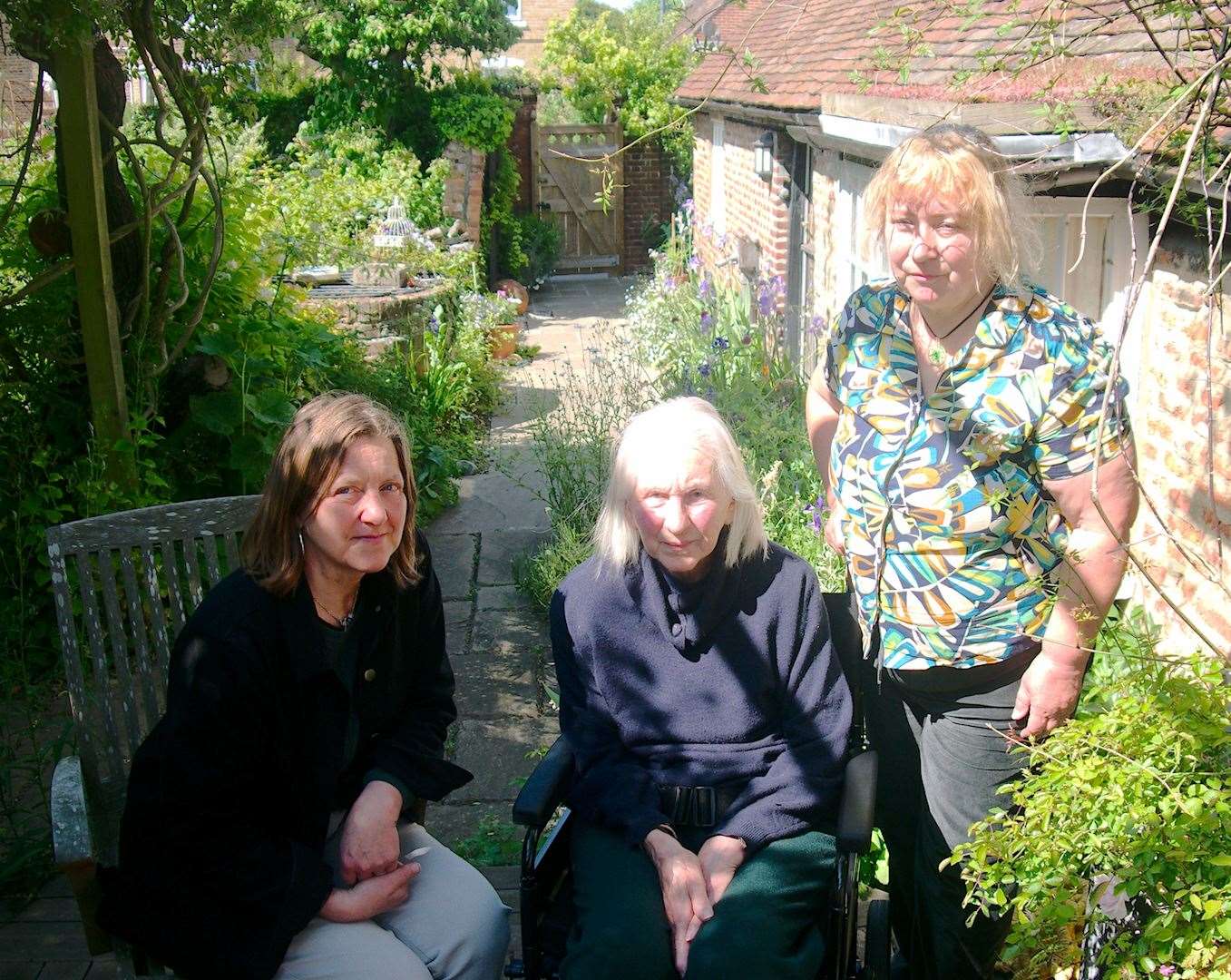 Zinnia Slade (centre) was “incredibly sad” to discover that the flowers which have bloomed outside her home for 50 years had been killed