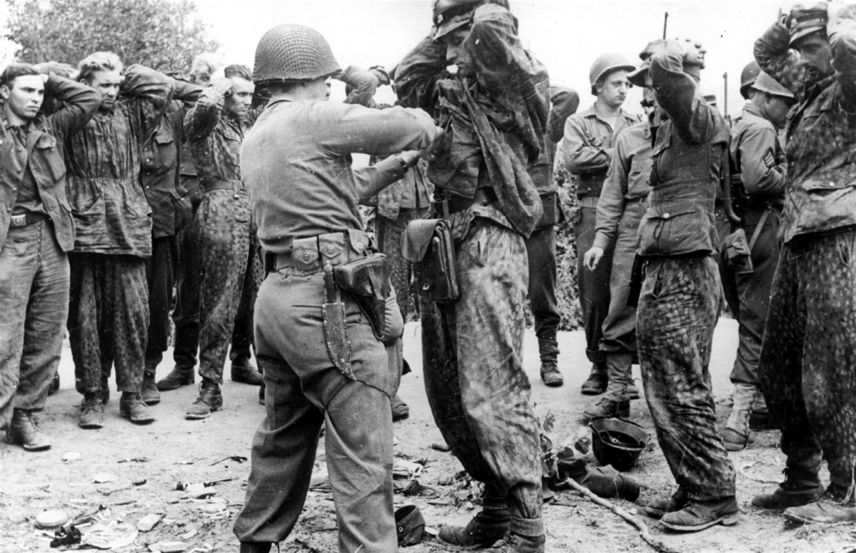 American soldiers search German prisoners from Normandy in the wake of the D-Day Landings of June 1944
