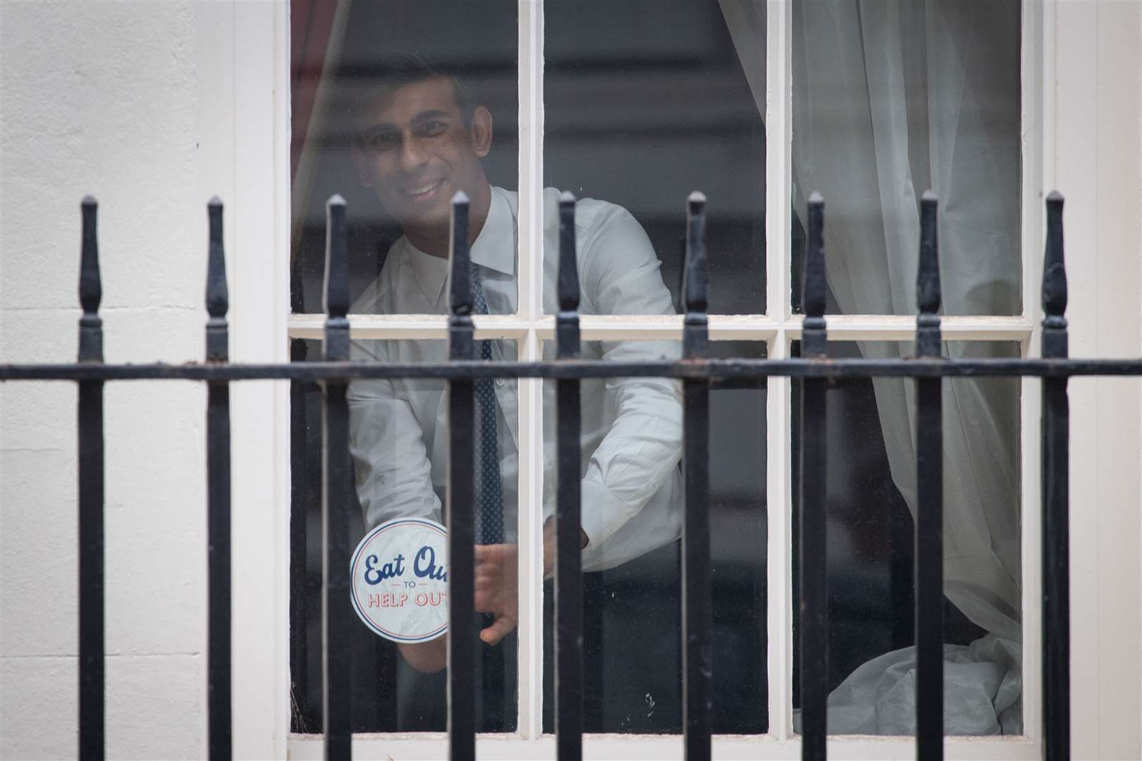Chancellor Rishi Sunak places an ‘Eat Out to Help Out’ sticker in the window of No 11 Downing Street (Stefan Rousseau/PA Wire)