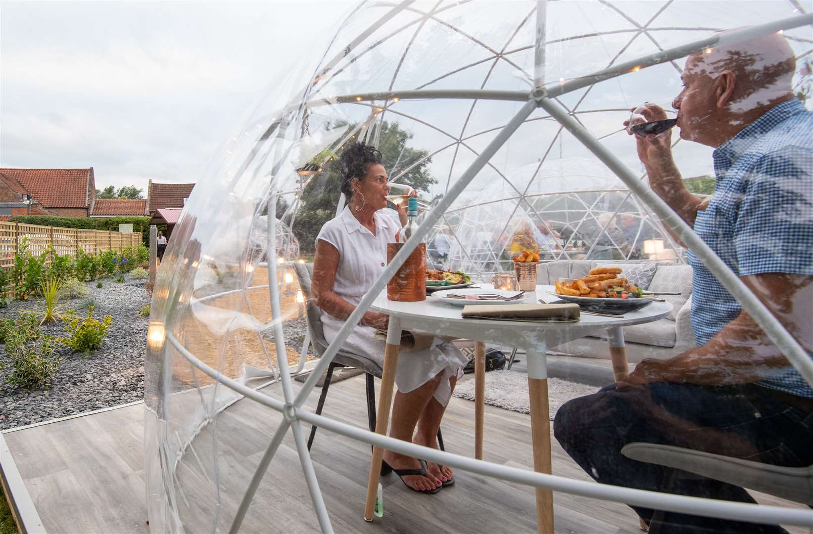 Sally and David Clayton enjoy a meal in one of the outdoor dining pods (Joe Giddens/ PA)