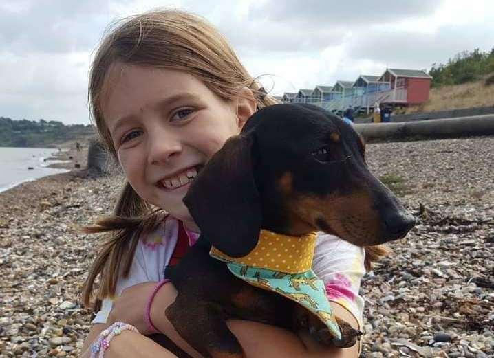 Archie the dachshund with his owner's daughter, Lola Watts