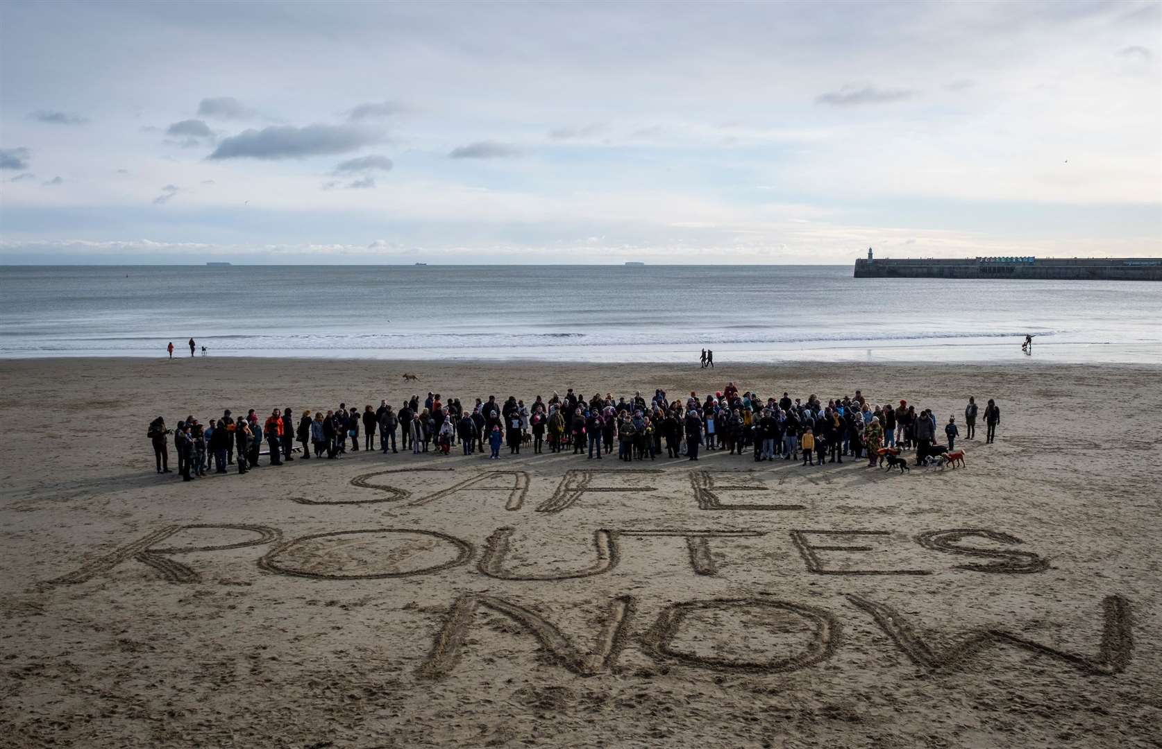 A slogan written in the sand calls for safe routes for asylum seekers. Picture: Andy Aitchison