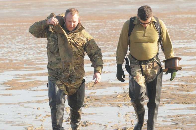 Two bomb disposal experts walk to shore with unexploded war-time shells. Picture: Steve Crispe