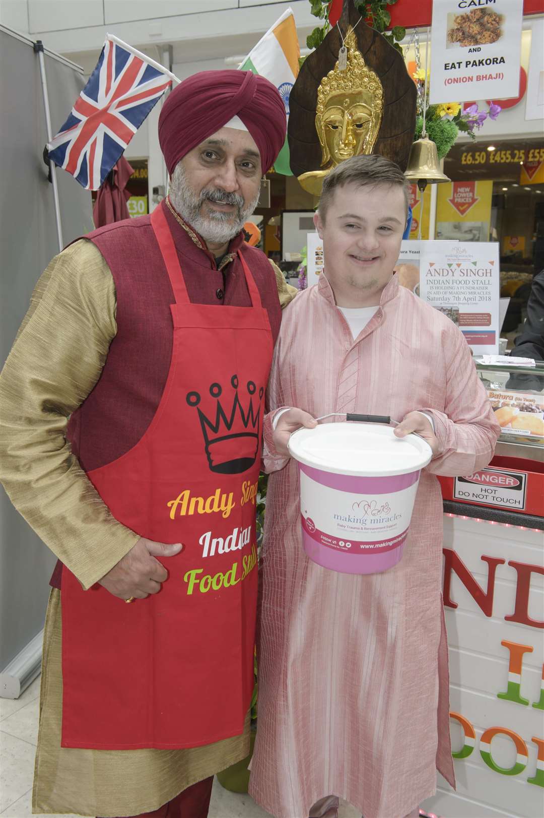 Andy Singh with regular fundraising assistant Brandon Holloway. Indian street food seller and character Andy Singh holds a fundraiser for charity Making Miracles, at his stall in the Thamesgate Shopping Centre, Gravesend. Picture: Andy Payton (1415297)