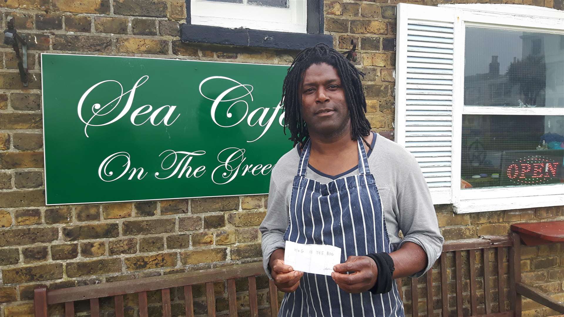 Cafe owner Peter St Ange with the note which contains the racist nickname