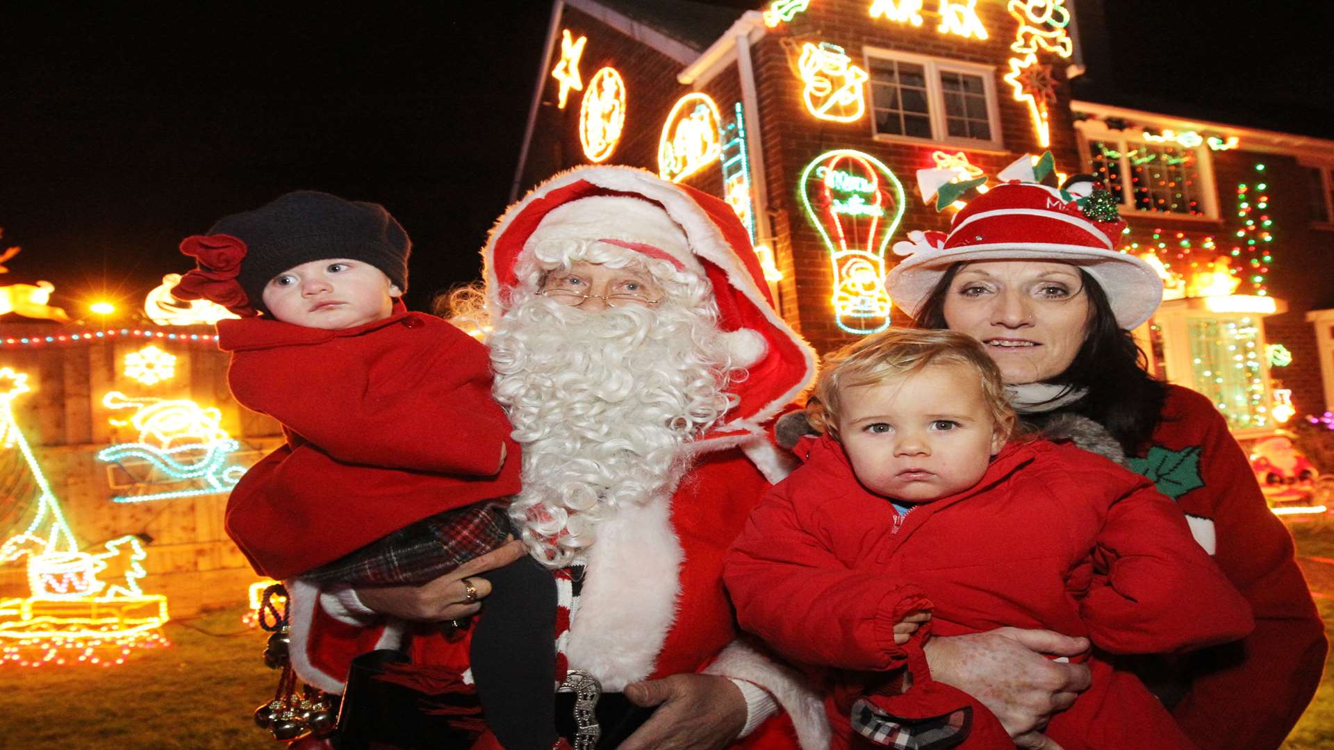Kevin Green, as Santa with Primrose Edwards, 14 months, Mrs Santa, Pat Green and Connor Green, 14 months old outside their house in Oak Drive, Larkfield