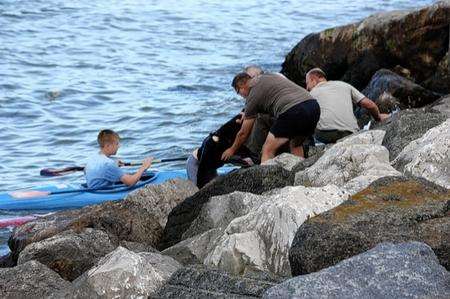 Rescuers help one of the children ashore