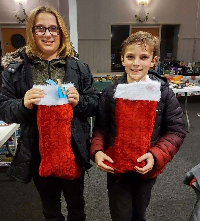 Two youngsters with Christmas stockings donated to Swale Foodbank by members of the Rotary Club of Sittingbourne Invicta