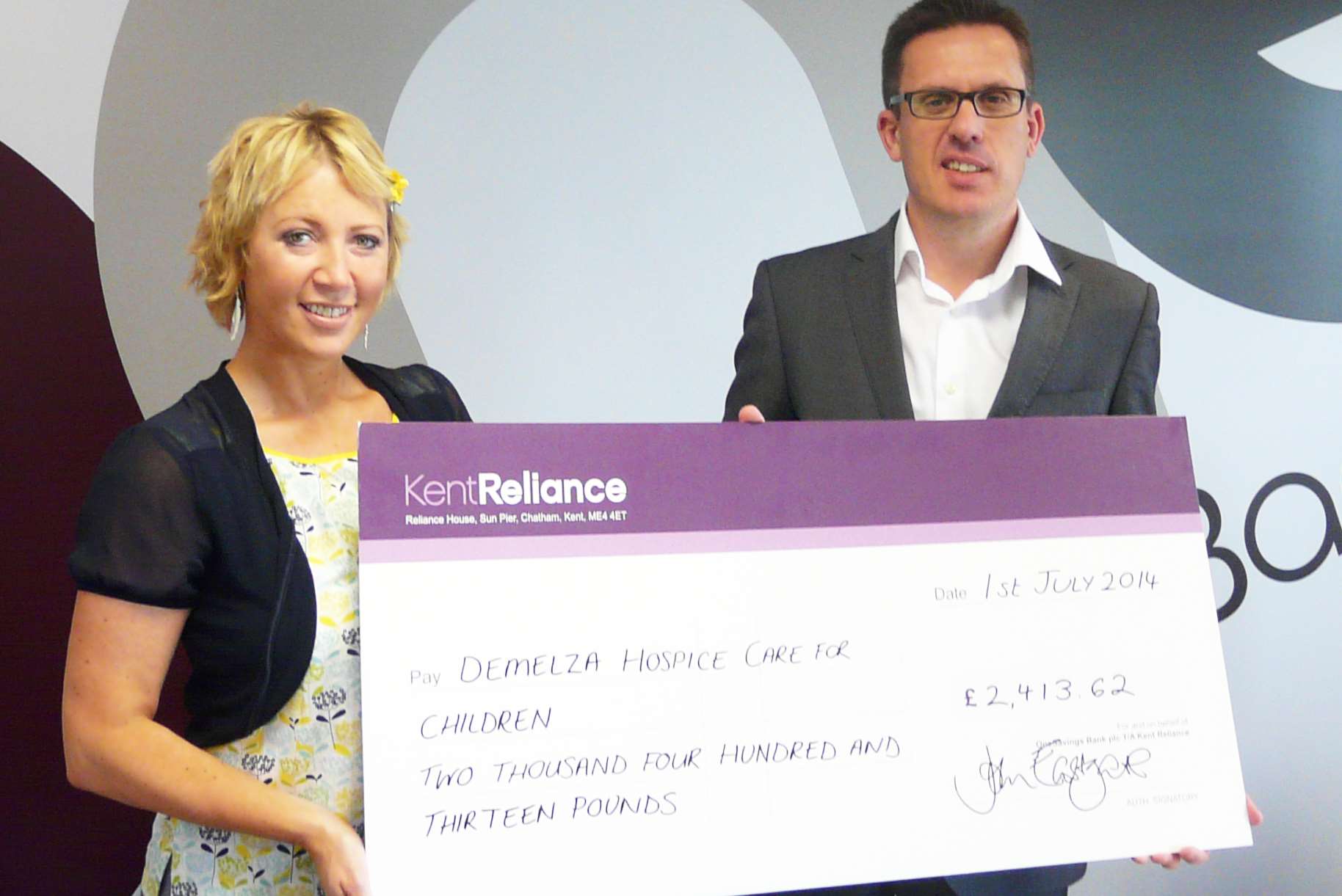 Kent Reliance's John Eastgate hands over the cheque to Natalie Tegg of Demelza