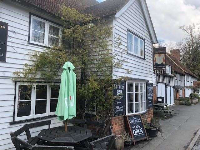 Approaching from the road in front, the outside of The Chequers Inn, Smarden, with its white weatherboards and traditional pub signs, hasn’t changed in many years
