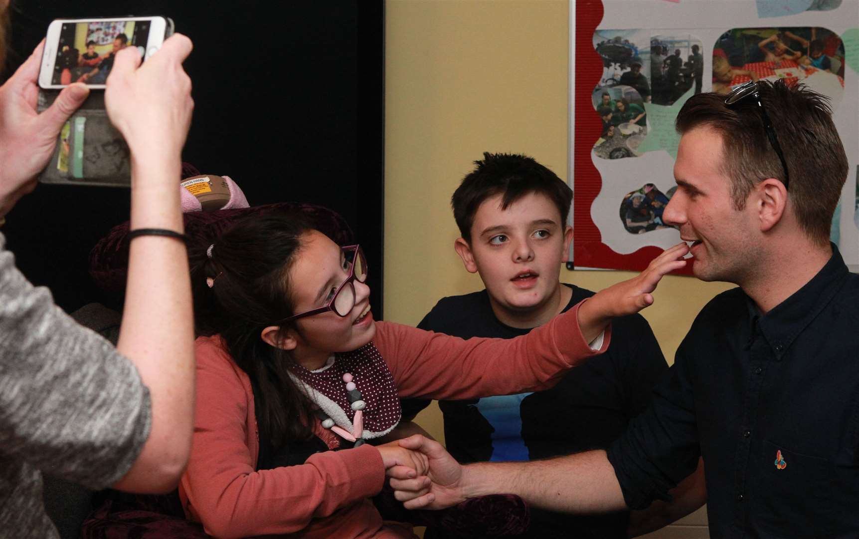 Richard Jones, right, winner of Britain's Got Talent in 2016, performs magic for Sinead Hann, her daughter, Lauren, 14, and son, Thomas, 11, during a show for children and families at Demelza
