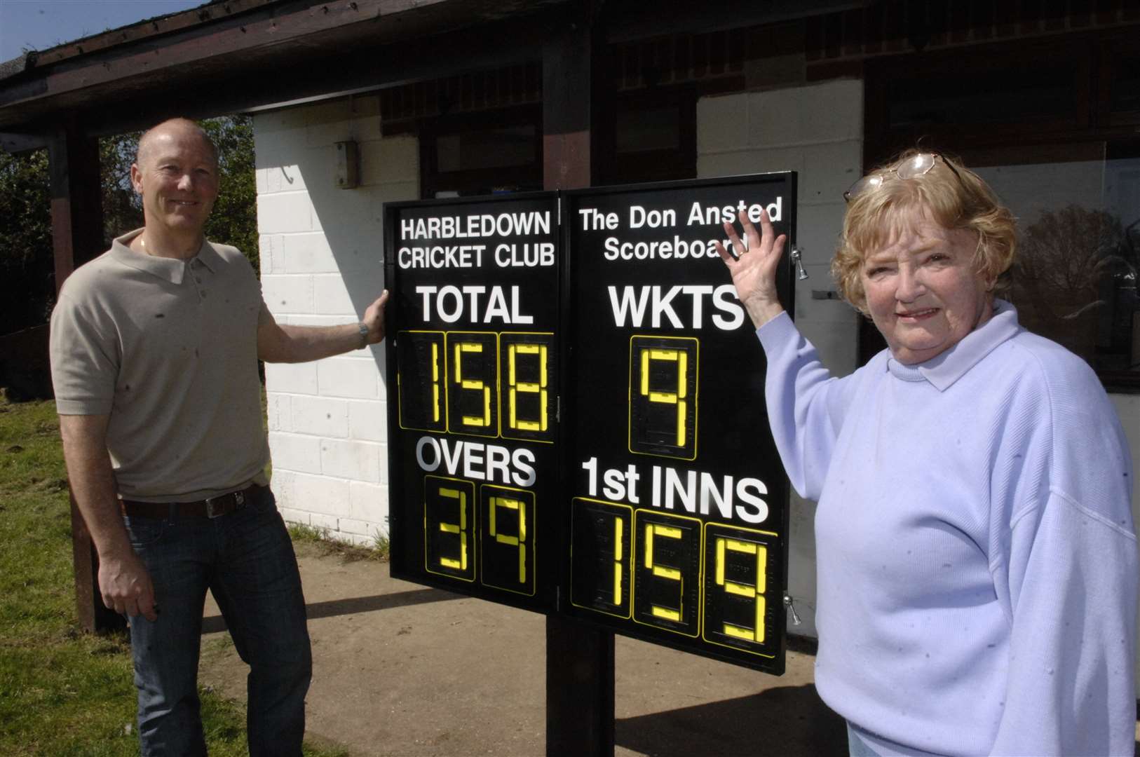 Former Kent and England cricketer Vince Wells with Margaret Ansted and the scoreboard in memory of Don Ansted at Harbledown Cricket Club, pictured in 2011. Picture: Chris Davey