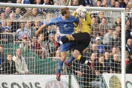 Mark Bentley challenges keeper Kieren Westwood during Gillingham's 2-0 win over Carlisle on Saturday. Picture: GRANT FALVEY