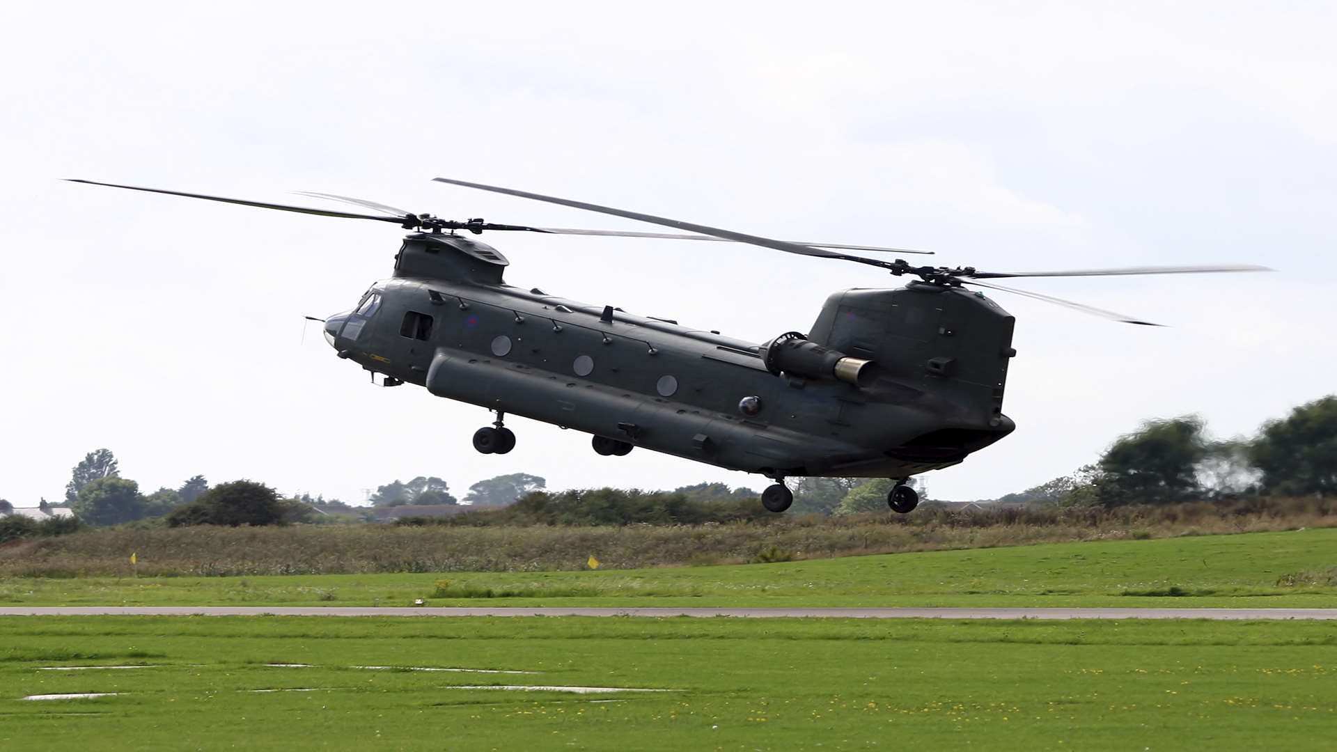 A chinook helicopter hovering over an airfield.