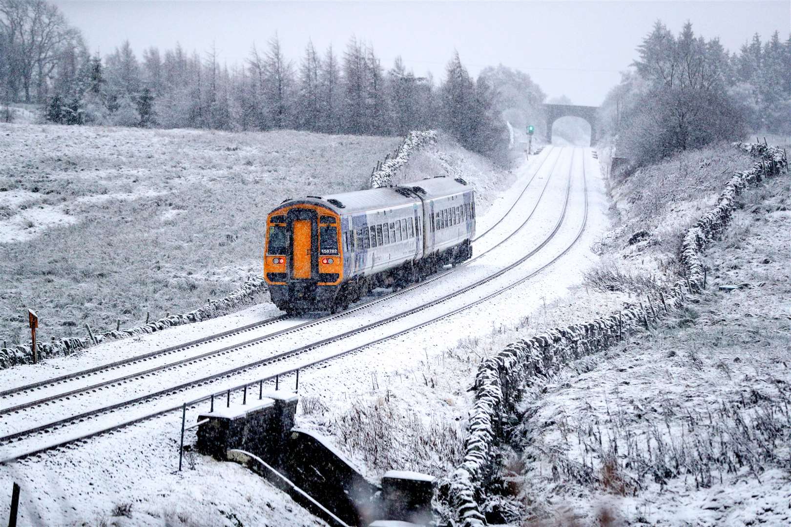 A train runs along the tracks in snowy North Yorkshire (Peter Byrne/PA)