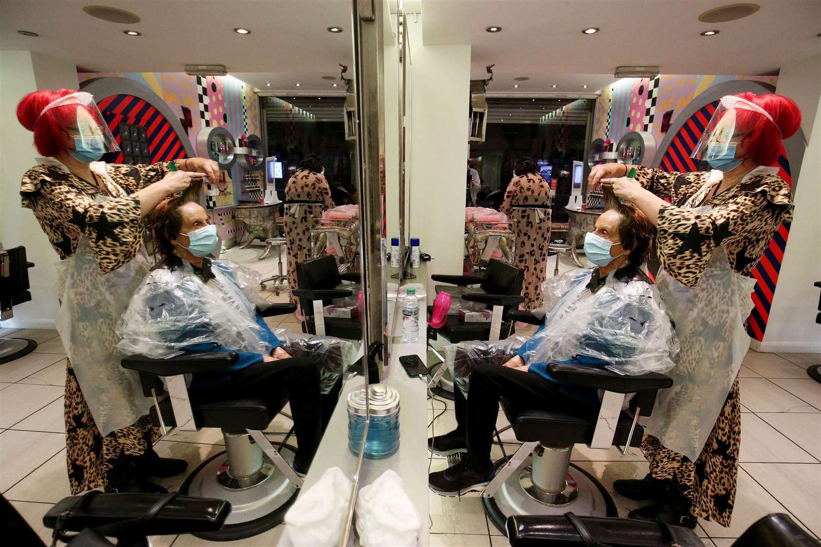 Carole Rickaby cuts the hair of customer Sandra Jacobs at Tusk Hair in Camden, north London, after opening at midnight as the first lockdown restrictions were eased in England (Jonathan Brady/PA)