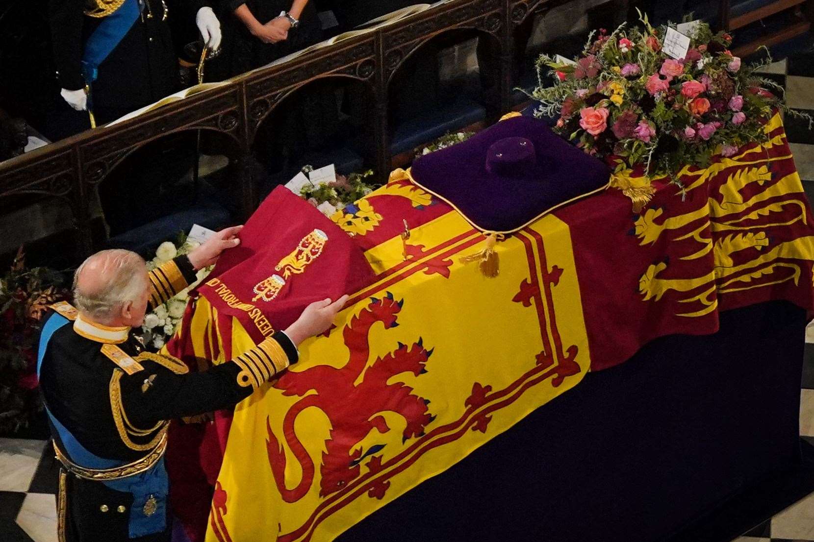 King Charles III places the the Queen’s Company Camp Colour of the Grenadier Guards on the coffin (Victoria Jones/PA)