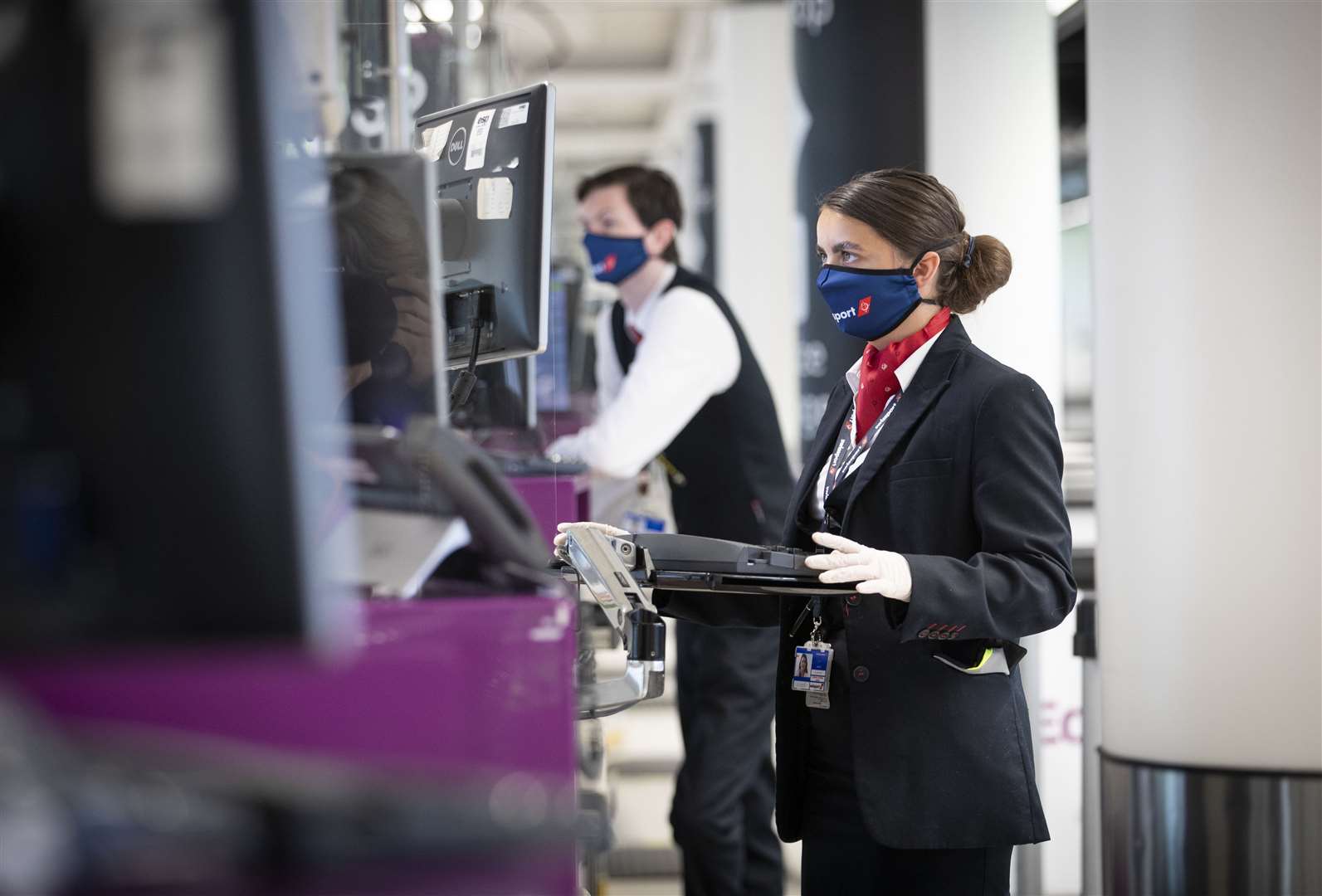 Check-in staff wear protective face masks at Edinburgh Airport (Jane Barlow/PA)