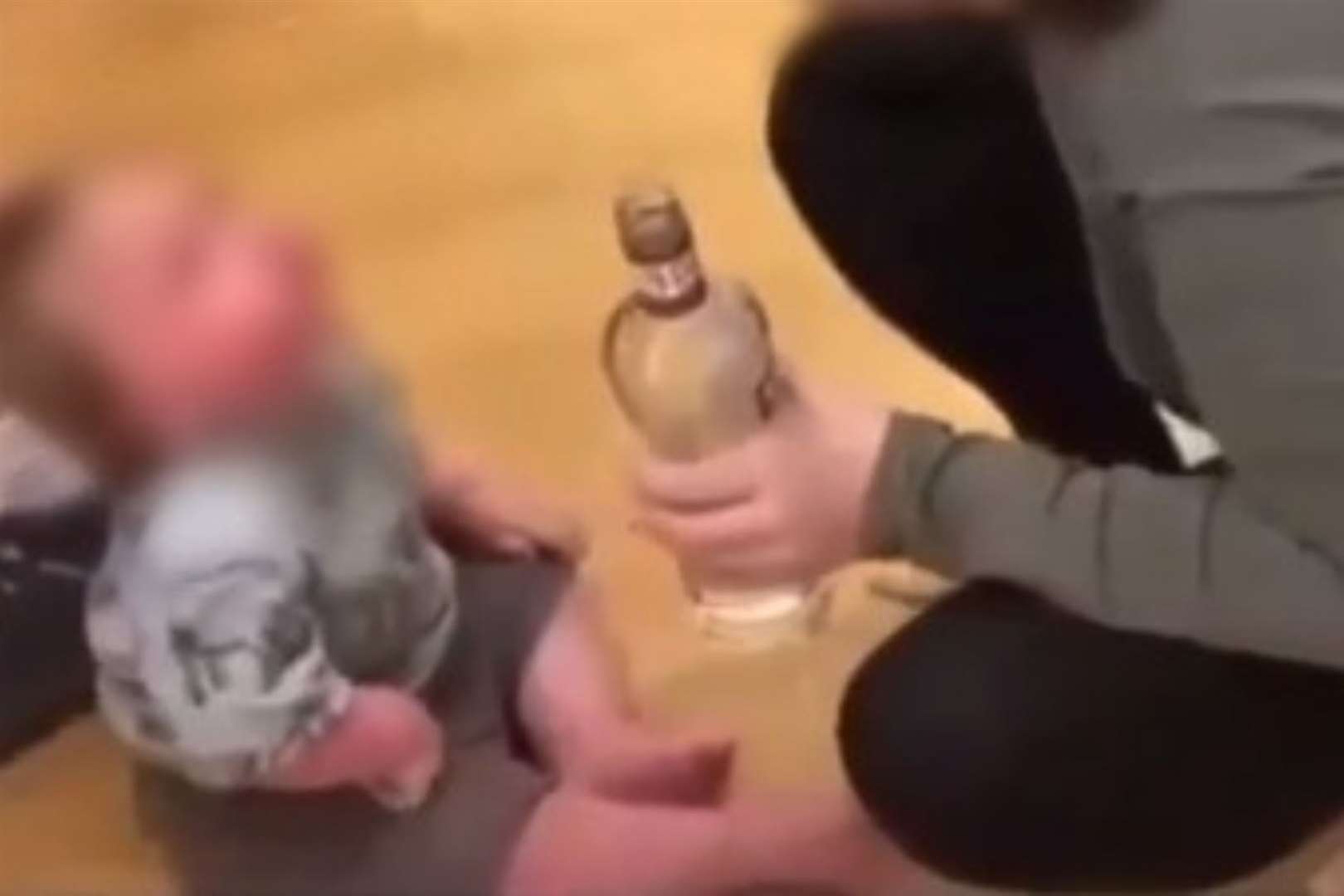 Two people were arrested after a video of a baby being given vodka appeared online
