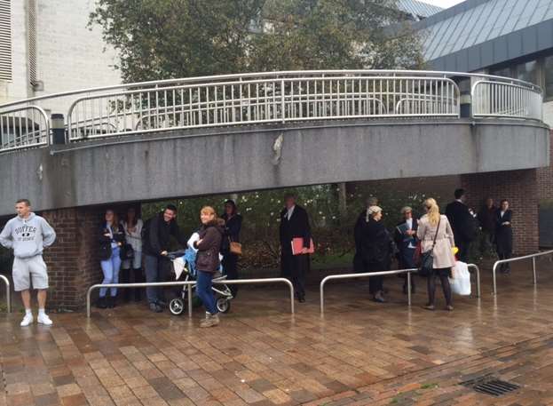 People shelter outside Maidstone Crown Court