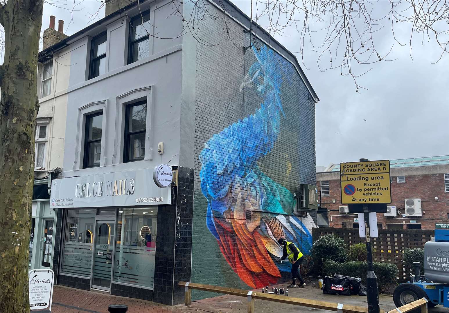 The mural is on a building which is home to a nail bar