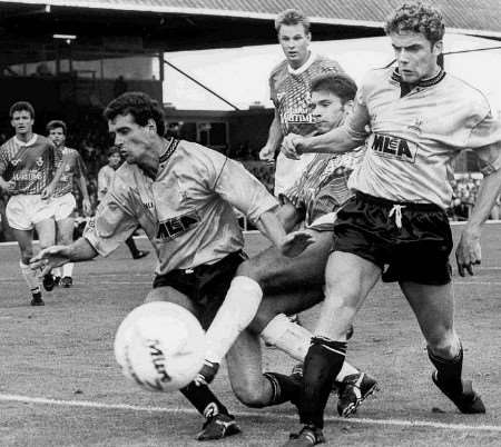 Kimble, playing for Gills in 1990, stretches a leg through the gap left by Maidstone players