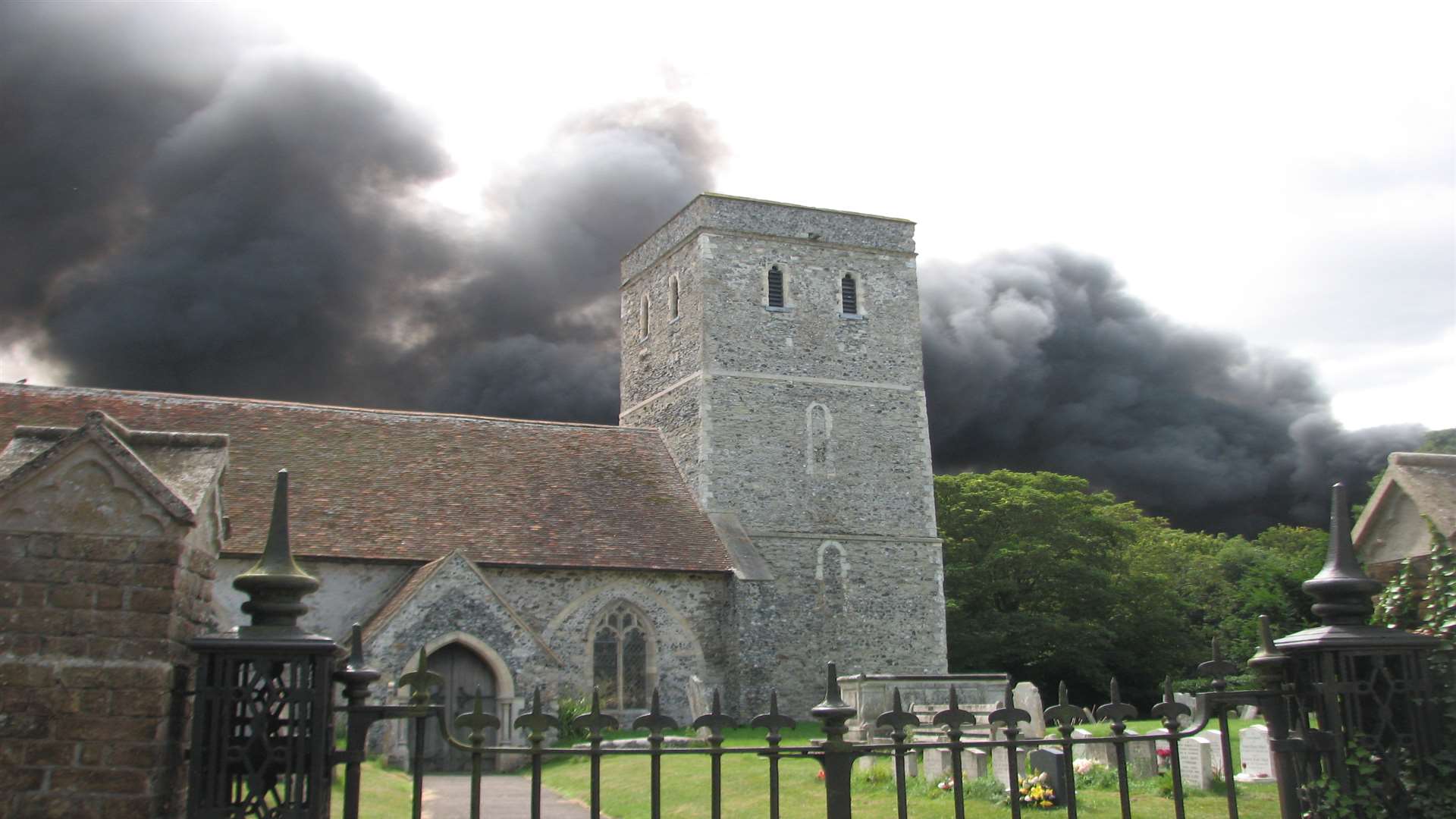 The smoke clouds can be seen over a nearby church. Picture: David Mairs