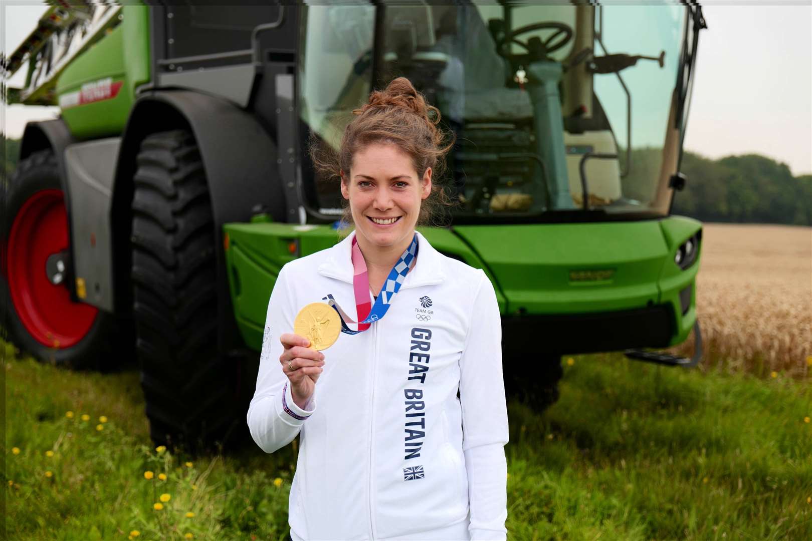 Kate French, from Meopham poses with her gold medal next to the crop sprayer named 'Tokyo' after her triumph in the 2020 Olympic Games.