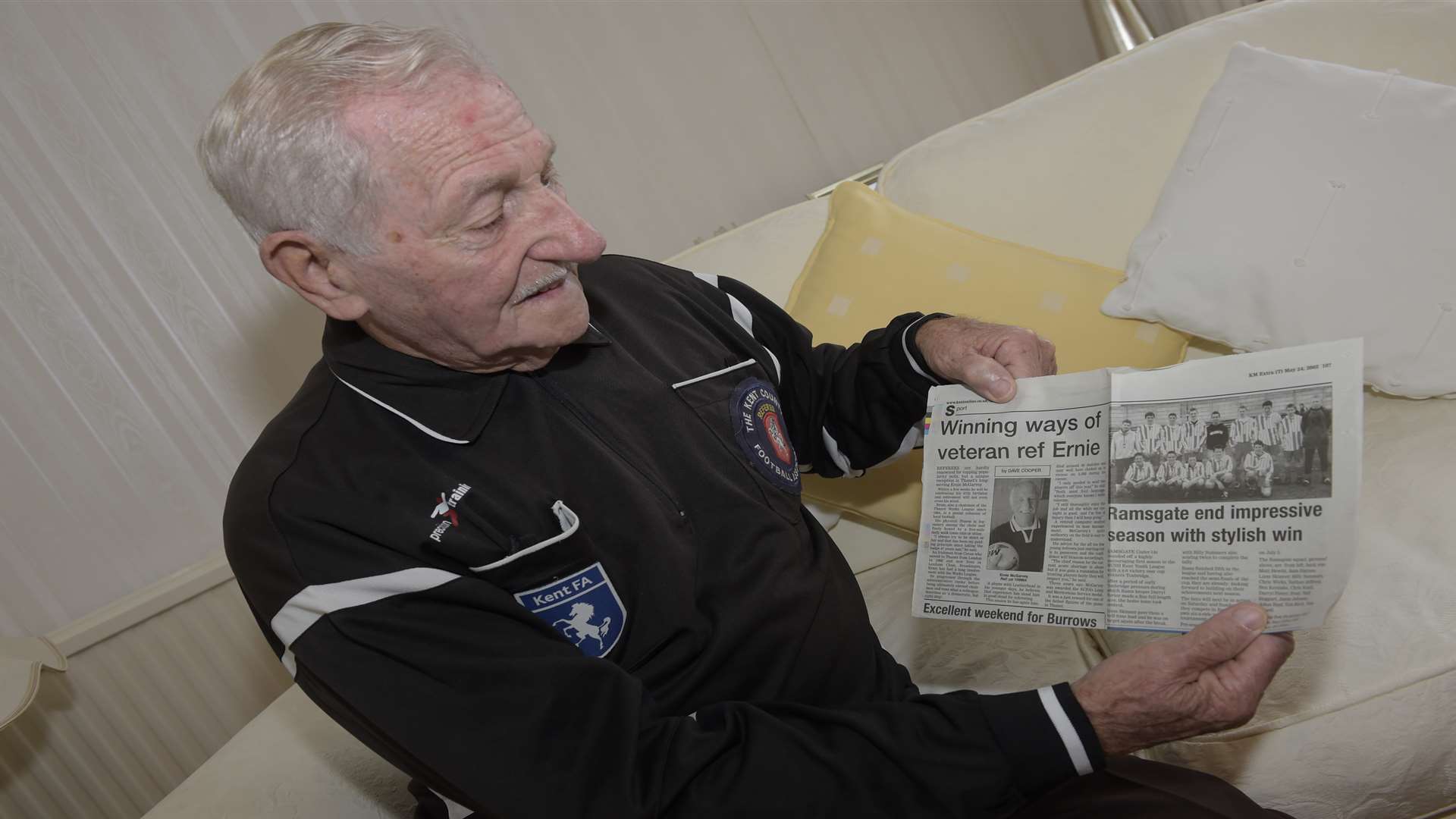 Ernie looks at a newspaper article charting his career as a referee