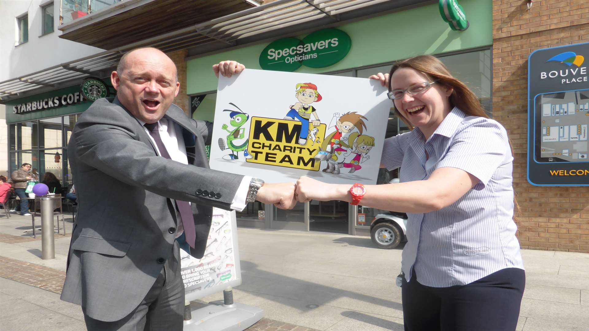 Folkestone Supersavers director David Cavender and manager Dani Ward showcase support for KM Charity Team's reading initiative Buster's Book Club.