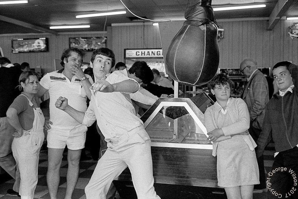This man puts his all into the punch machine at Cain's amusements. Copyright: George Wilson