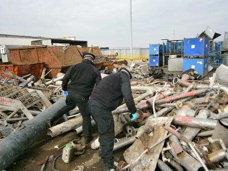 Officers search a Kent scrap yard