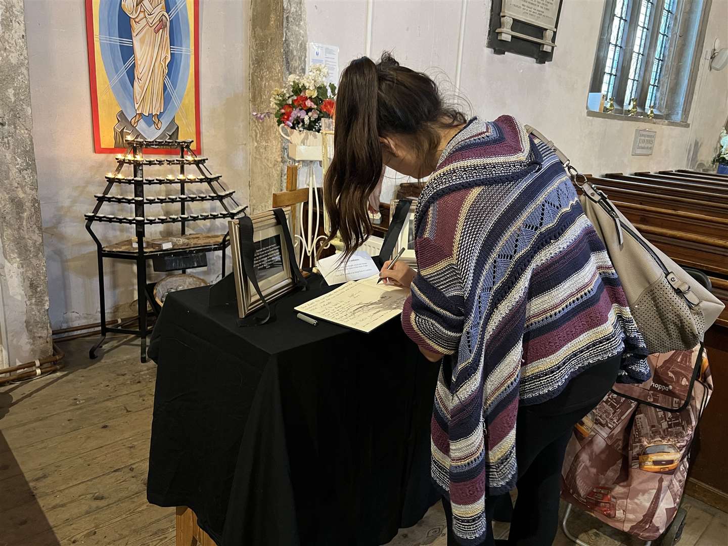 Someone writing in the book of condolence at St Michael's Church, Sittingbourne