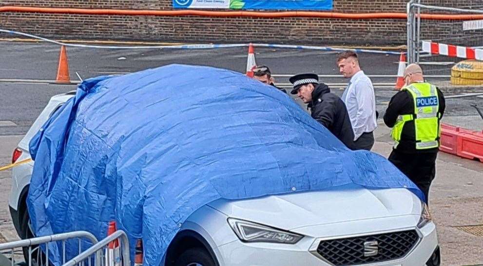 Police examine the car at the petrol station
