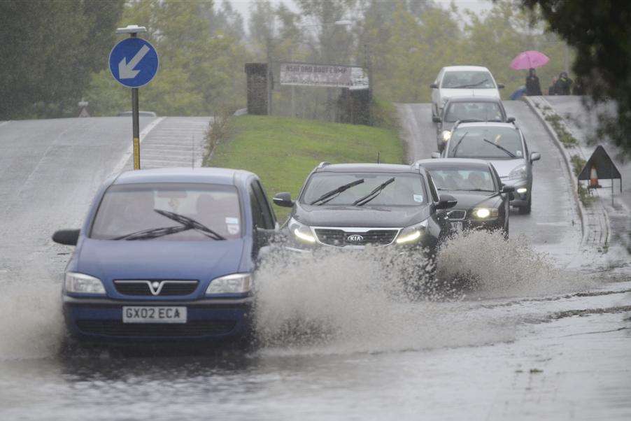 Cars negotiate flooding near the Julie Rose stadium in Ashford. Picture: Gary Browne