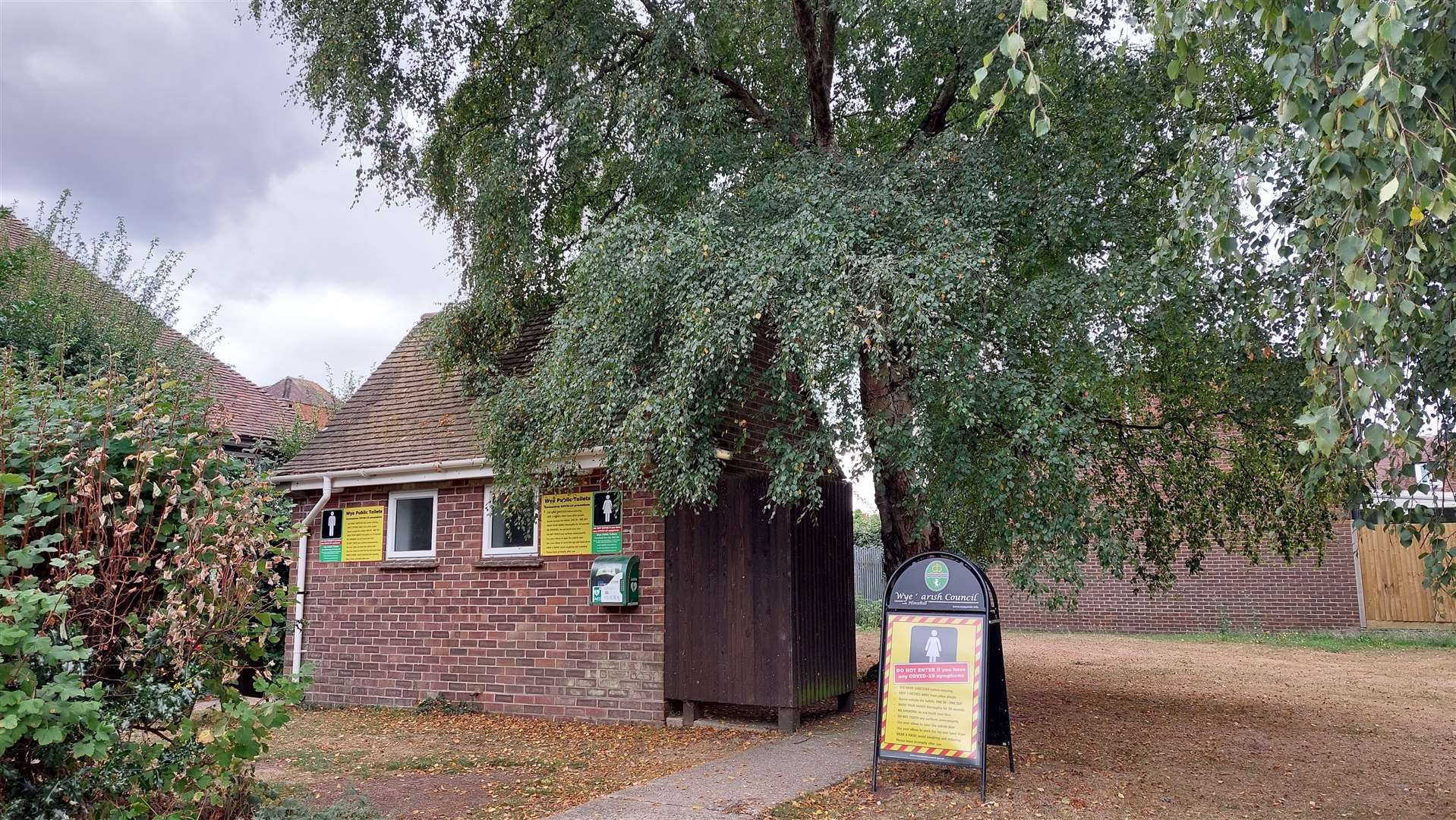 The tree is next to a toilet block in Churchfield Way