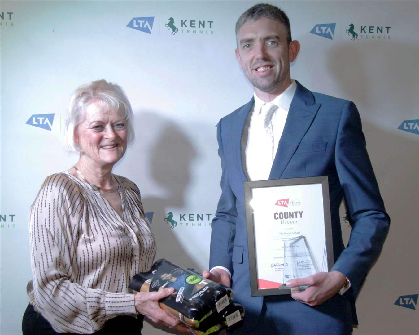Head tennis coach Andrew Sunderland picks up the award for School of the Year from Kent LTA president Mary Evans