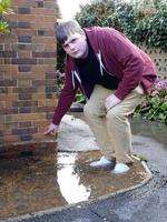 Sam Gillham shows where water rose to two bricks-high outside his home in Minster Road.