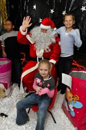 Kane Toussaint, nine, Bethan Walters, nine, and Lauren Walters, six, with Father Christmas in his grotto