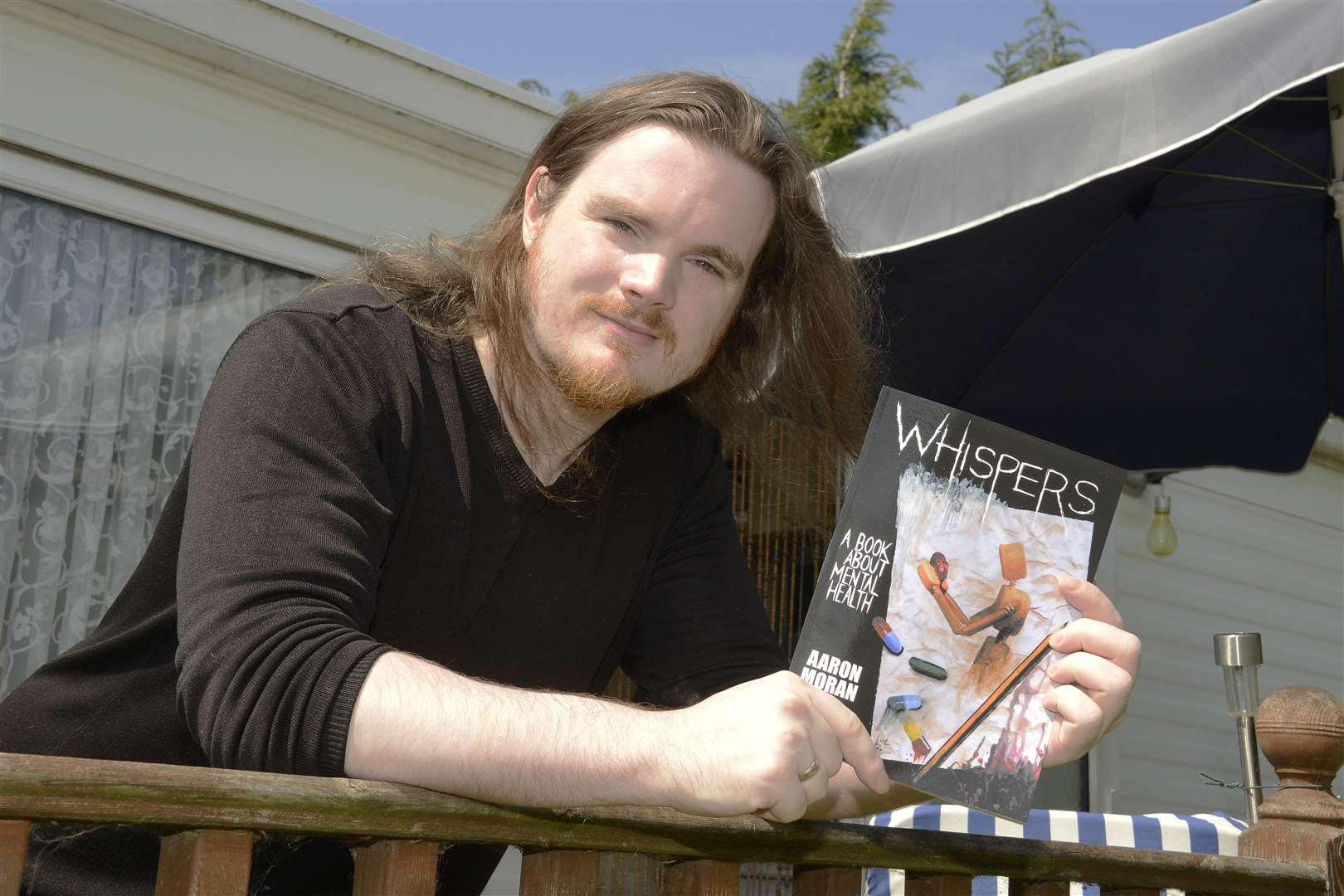 Aaron Moran with his book Whispers. Picture: Paul Amos