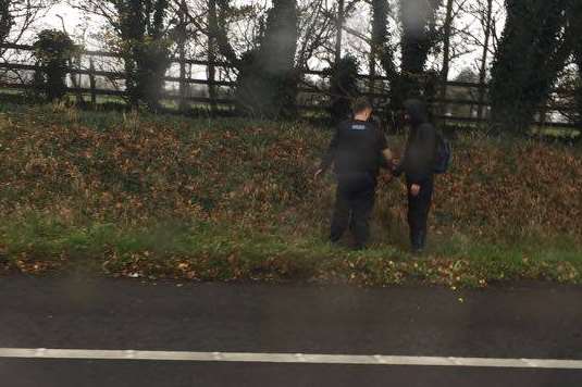 A police officer speaks to one of the 'suspected migrants' on the hard shoulder of the M2.