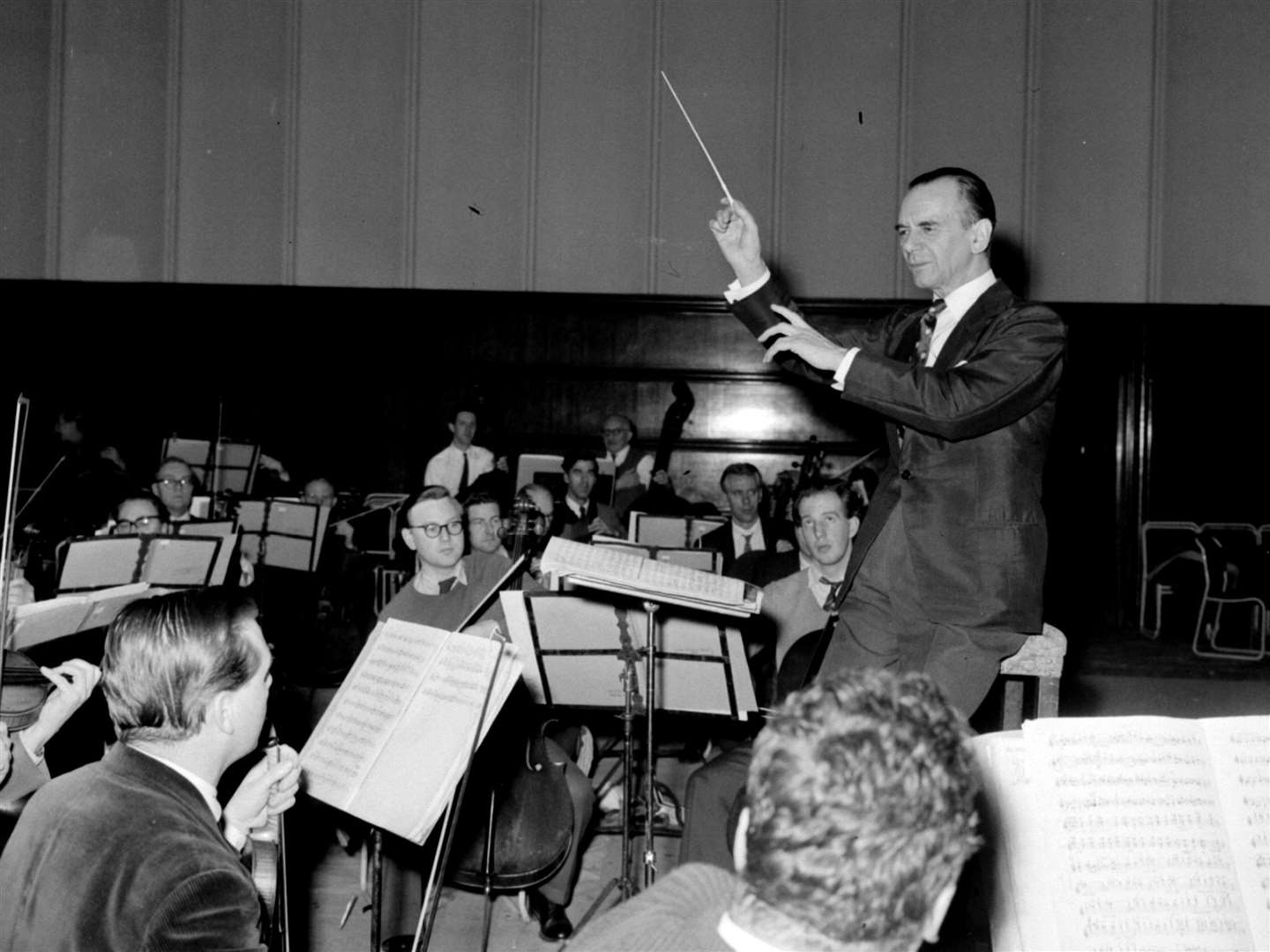 Sir Malcolm Sargent in inimitable style, leading members of the London Philharmonic Orchestra (PA Archive/PA Images)