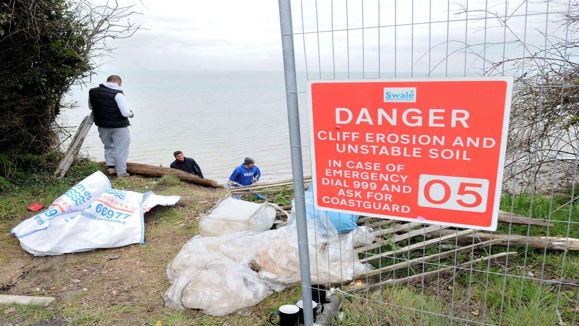 Contractors putting in netting to prevent cliff erosion