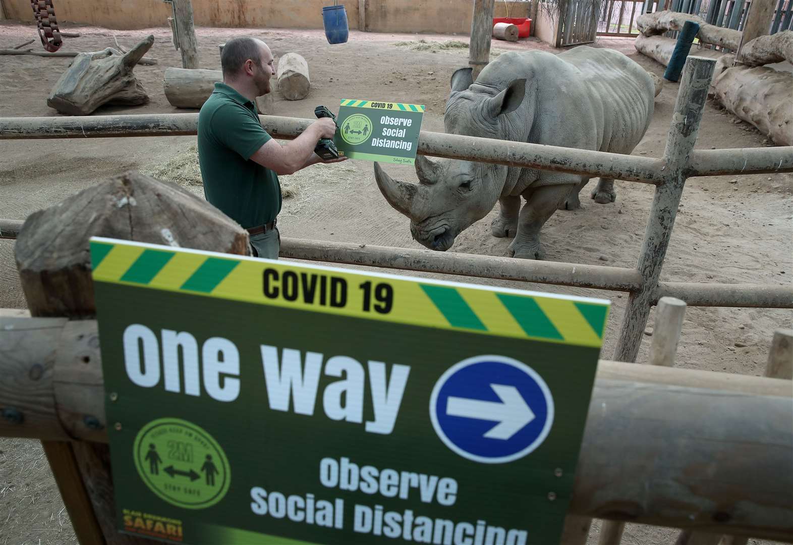 Operations supervisor Dave Warren installs signs in the rhino yard explaining social distancing measures (Andrew Milligan/PA)
